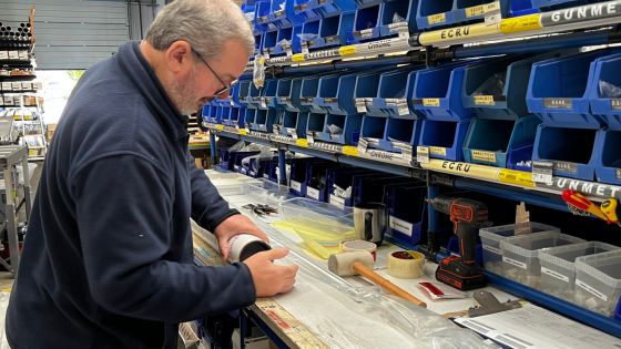 Tracks Direct warehouse, man packing a curtain pole and track for shipping