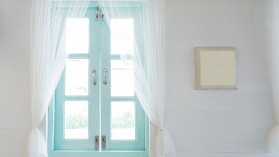 Sky blue window frame with white lightweight curtains