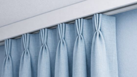 triple pleat curtains in a soft blue colour handing fro a recessed track
